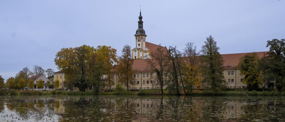 24.10.2022, Brandenburg, Neuzelle: Der Turm der Stiftskirche St. Marien auf dem Gelände vom Zisterzienserkloster Neuzelle und weitere Gebäude des Klosterensembles spiegeln sich im Klosterteich. Foto: Monika Skolimowska/dpa/ZB - Honorarfrei nur für Bezieher des Dienstes ZB-Funkregio Ost +++ ZB-FUNKREGIO OST +++