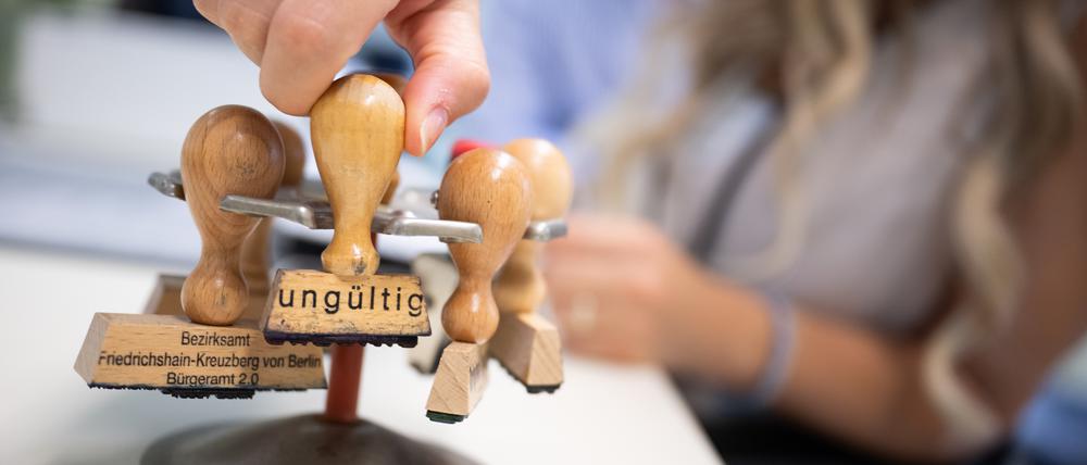 Eine Frau nimmt im Ausbildungsbürgeramt einen Stempel mit der Aufschrift «ungültig» aus einem Stempelhalter. Bei der Halbzeit-Klausur des Bundeskabinetts auf Schloss Meseberg will das Bundeskabinett unter anderem über Bürokratieabbau und Digitalisierung im Gesundheitswesen beraten.