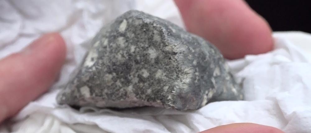 Ein mutmaßliches Meteoritenteil liegt in einem Papiertaschentuch.