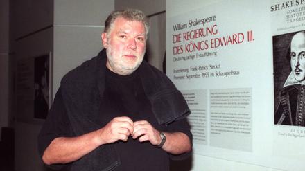 Regisseur Frank-Patrick Steckel neben einem Bild von William Shakespeare im Schauspielhaus Köln  