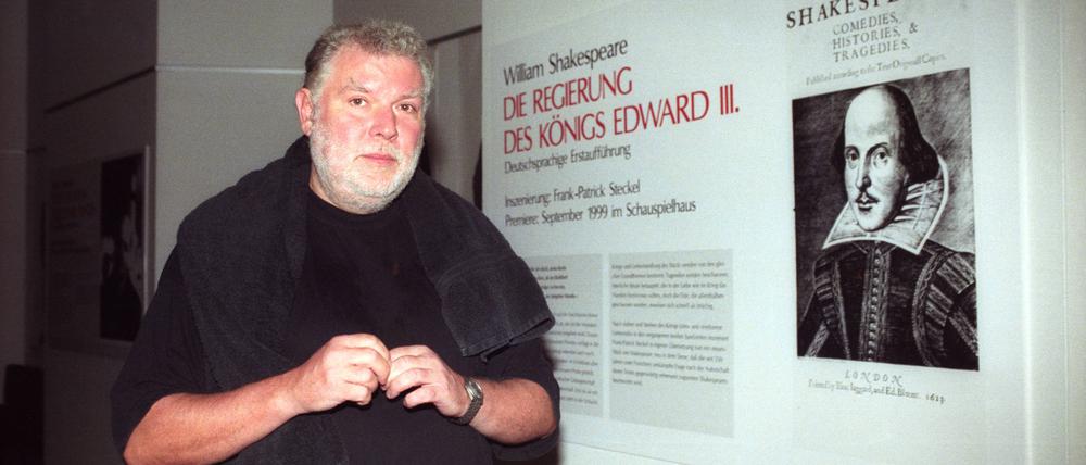 Regisseur Frank-Patrick Steckel neben einem Bild von William Shakespeare im Schauspielhaus Köln