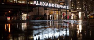 Menschen laufen am frühen Morgen vor dem Fernsehturm über den Alexanderplatz.