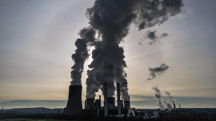 Dampf steigt vor der Sonne aus dem RWE Braunkohlekraftwerk Niederaußem. Das Kraftwerk Niederaußem ist ein von RWE Power mit Braunkohle betriebenes Grundlastkraftwerk. 