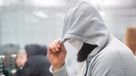 Abu Walaa, mutmaßlicher Anführer der Terrormiliz Islamischer Staat (IS) in Deutschland, steht im Oberlandesgericht hinter einer Glasscheibe.