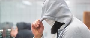Abu Walaa, mutmaßlicher Anführer der Terrormiliz Islamischer Staat (IS) in Deutschland, steht im Oberlandesgericht hinter einer Glasscheibe.