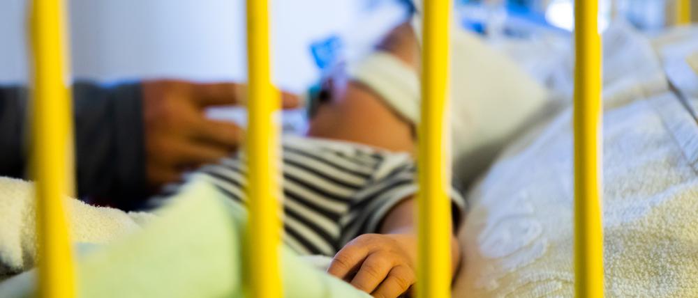 Ein Kind wird in einem Krankenhausbett beatmet.