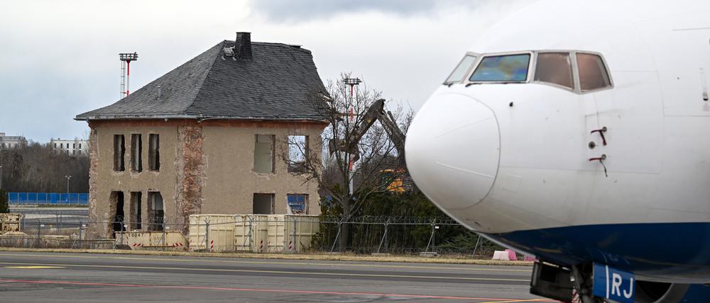 31.01.2024, Brandenburg, Schönefeld: Ein Bagger arbeitet am Abriss des ehemaligen Generalshotel auf dem Gelände des Flughafens Berlin Brandenburg (BER) (Aufnahme hinter einem Metallzaun). Im Vordergrund steht eine stillgelegte Boeing 767 der Fluggesellschaft Star Air. Foto: Soeren Stache/dpa +++ dpa-Bildfunk +++