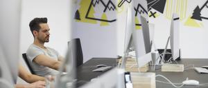Ein Mann arbeitet im Großraumbüro am Computer.