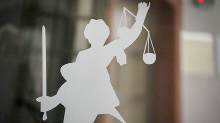 ARCHIV - 27.04.2023, Berlin: Die Figur der Justitia mit Richtschwert und Waage ist auf dem Glasfenster einer Tür im Kriminalgericht Moabit in Berlin zu sehen. (zu dpa: «Betrug durch falsche Bankmitarbeiter - 35-Jähriger vor Gericht») Foto: Soeren Stache/dpa +++ dpa-Bildfunk +++