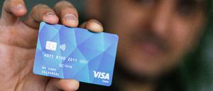 Eine Person zeigt eine Visa-Karte in die Kamera.