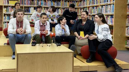 Darja Herassymtschuk (2.v.r), Beauftragte des ukrainischen Präsidenten für Kinderrechte und Kinderrehabilitation, und neun aus Russland zurückgekehrte ukrainische Kinder bei einem Gespräch mit der Presse.