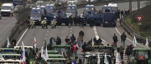 Landwirte und Traktoren stehen Militärfahrzeugen auf einer Autobahn gegenüber.