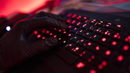 Ein Mann trägt Handschuhe und tippt auf einer Tastatur (Archivbild).
