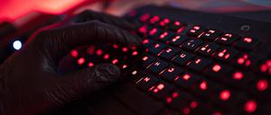 Ein Mann trägt Handschuhe und tippt auf einer Tastatur (Archivbild).