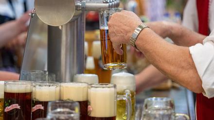 ARCHIV - 22.01.2024, Berlin: Ein Mann gießt Bier vom Zapfhahn ins Glas in einer Ausstellungshalle auf der Grünen Woche.  (zu dpa: «Das Bier läuft nicht mehr - Brauereien in der Zange») Foto: Monika Skolimowska/dpa +++ dpa-Bildfunk +++