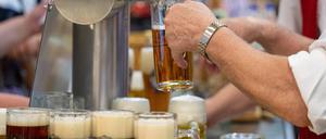 ARCHIV - 22.01.2024, Berlin: Ein Mann gießt Bier vom Zapfhahn ins Glas in einer Ausstellungshalle auf der Grünen Woche.  (zu dpa: «Das Bier läuft nicht mehr - Brauereien in der Zange») Foto: Monika Skolimowska/dpa +++ dpa-Bildfunk +++