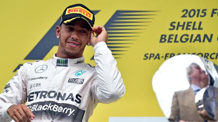 (FILES) Mercedes AMG Petronas F1 Team's British driver Lewis Hamilton looks at the trophy as he celebrates winning on the podium at the Spa-Francorchamps circuit in Spa on August 23, 2015, after the Belgian Formula One Grand Prix. Seven-time Formula One world champion Lewis Hamilton will leave Mercedes at the end of the 2024 season, the team announced February 1, 2024, ahead of an expected move to Ferrari for 2025 season. "Lewis has activated a release option in the contract announced last August and this season will therefore be his last driving for the Silver Arrows," Mercedes said in a statement. (Photo by ANDREJ ISAKOVIC / AFP)