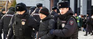 Polizeibeamte führen bei einer Protestaktion russischer Frauen in Moskau eine Person ab.