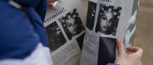 Ein junges Mädchen, das mit einer Gruppe Jugendlicher unterwegs ist, klebt in einem Park zwischen den U-Bahnhöfen Johannisthaler Chaussee und Britz-Süd Flugblätter an einen Laternenpfahl.