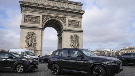 31.01.2024, Frankreich, Paris: Ein Sport Utility Vehicles (SUV) fährt auf dem Avenue Champs Elysees, in der Nähe des Arc de Triomphe.