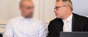 Der Angeklagte im Prozess zu einer mutmaßlichen Geiselnahme (links) wartet im Schwurgerichtssaal des Landgericht Karlsruhe zusammen mit seinem Anwalt Alexander Kist auf den Beginn des Prozess. Dem 21 Jahre alten Mann wird unter anderem erpresserischer Menschenraub mit Geiselnahme und Freiheitsberaubung sowie versuchte, besonders schwere räuberische Erpressung vorgeworfen. Er hatte im März vergangenen Jahres in einer Karlsruher Apotheke drei Menschen mit einer Schreckschusswaffe bedroht und als Geiseln genommen.