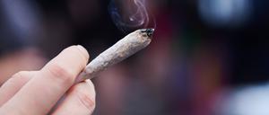 Eine Frau hält einen Joint in der Hand. 