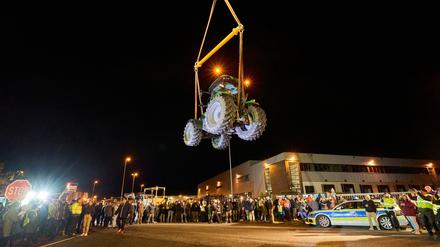 Ein Traktor schwebt an einem Kran hängend vor einem Lidl-Zentrallager. Landwirte hatten den 6 Tonnen schweren Deutz-Schlepper während einer Protestaktion aufgehängt. Der Protest richte sich gegen die Agrarpolitik, so die Organisatoren.