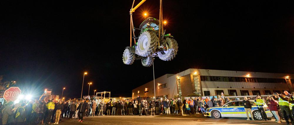 Ein Traktor schwebt an einem Kran hängend vor einem Lidl-Zentrallager. Landwirte hatten den 6 Tonnen schweren Deutz-Schlepper während einer Protestaktion aufgehängt. Der Protest richte sich gegen die Agrarpolitik, so die Organisatoren.