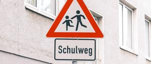 Ein Verkehrsschild warnt zum Langsamfahren vor einem Schulweg.