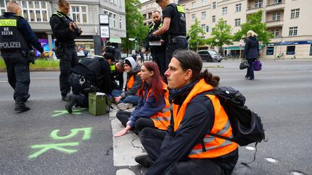 Polizisten entfernen Kleber von der Hand eines Aktivisten der „Letzte Generation“ (Archivbild vom 16. Mai 2023).