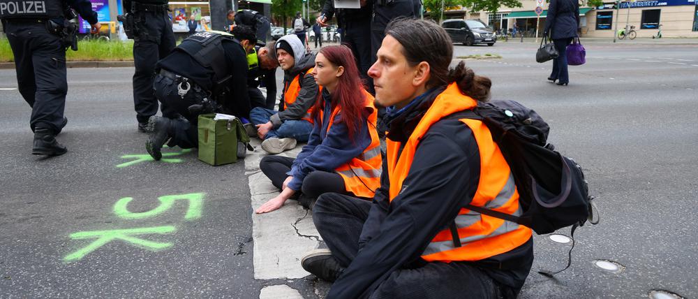 Polizisten entfernen Kleber von der Hand eines Aktivisten der „Letzte Generation“ (Archivbild vom 16. Mai 2023).