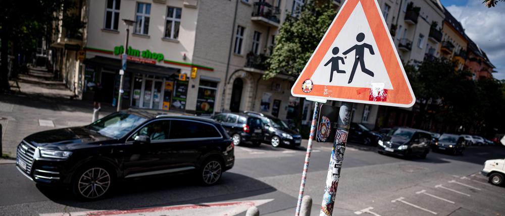 Ein SUV fährt an einem Hinweisschild für Schüler in der Prenzlauer Allee vorbei (Archivbild vom 10.08.2023).