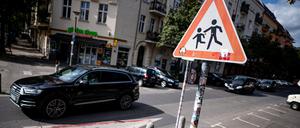Ein SUV fährt an einem Hinweisschild für Schüler in der Prenzlauer Allee vorbei (Archivbild vom 10.08.2023).