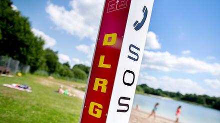 Eine Notrufsäule der DLRG steht an einem Badesee.