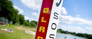 Eine Notrufsäule der DLRG steht an einem Badesee.