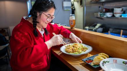 Sissi Chen vor einem Teller Erdnussnudeln im „Noodle Freunde“.