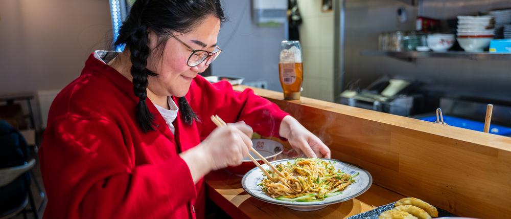 Sissi Chen vor einem Teller Erdnussnudeln im „Noodle Freunde“.