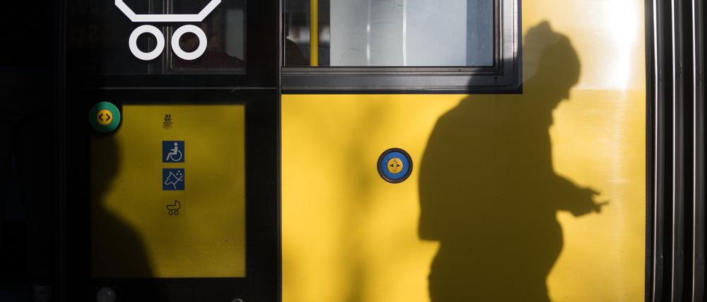 Ein Mann geht an einer Tram der BVG entlang.