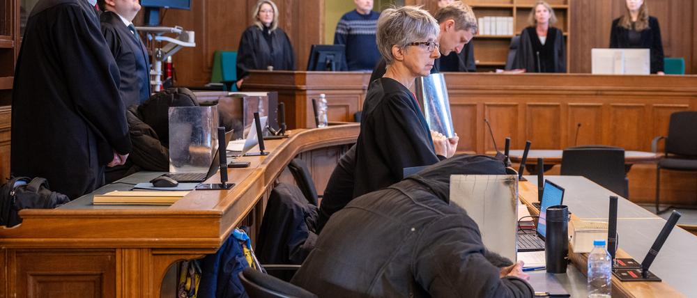 Vier Angeklagte sitzen vor Beginn der Verhandlung im Gerichtssaal im Kriminalgericht Moabit in Begleitung ihrer Anwälte Regina Götz (vorne r), Einar Aufurth (hinten r), Marten Mittelstädt (vorne l) und Michael Lippa (hinten l) und verdecken dabei ihre Gesichter mit Pappe. Fast vier Jahre nach dem Angriff auf ein ZDF-Team am Rande einer Demonstration gegen die staatlichen Corona-Maßnahmen in Berlin begann am 8.1.2024 der Prozess gegen drei Männer und eine Frau aus Berlin und Baden-Württemberg. Das Urteil ist nun rechtskräftig.