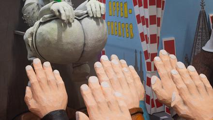 Ein Motivwagen, der einen Hintern und zum Hitlergruß ausgestreckte Arme zeigt, steht beim Richtfest für den Kölner Rosenmontagszug im Karnevalsmuseum. 