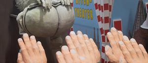 Ein Motivwagen, der einen Hintern und zum Hitlergruß ausgestreckte Arme zeigt, steht beim Richtfest für den Kölner Rosenmontagszug im Karnevalsmuseum.