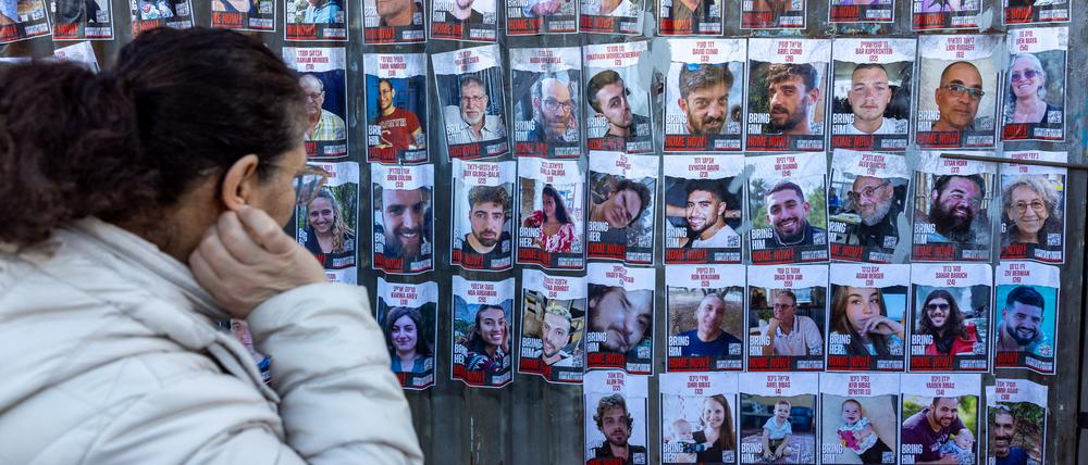 Eine Frau schaut auf Poster der von der Hamas entführten Geiseln.