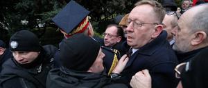 Der PiS-Politiker Mariusz Kaminski (Mitte) wird von der Parlamentswache blockiert. 