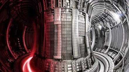 Der Innenraum des Fusionsexperiments JET mit einer darübergelegten Aufnahme des Plasmas.