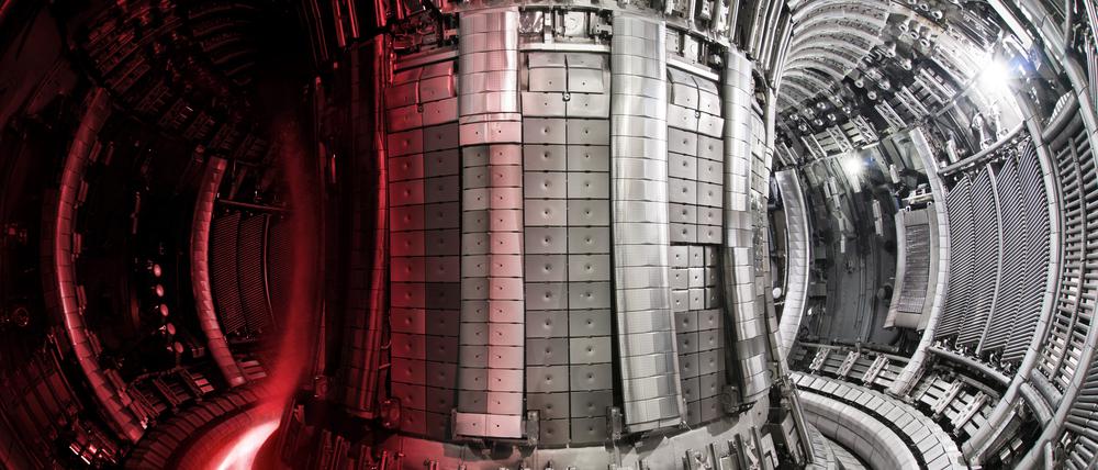 Der Innenraum des Fusionsexperiments JET mit einer darübergelegten Aufnahme des Plasmas.