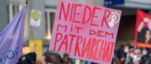Frauentagsdemo in München, Demonstrantin hält Schild mit der Aufschrift: Nieder mit dem Patriarchat .