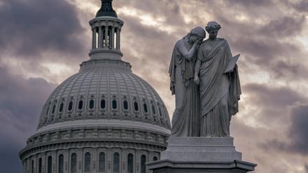Blick auf das Friedensdenkmal und die Kuppel des US-Kapitols bei bewölktem Himmel. 