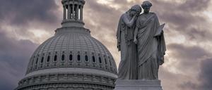 Blick auf das Friedensdenkmal und die Kuppel des US-Kapitols bei bewölktem Himmel. 