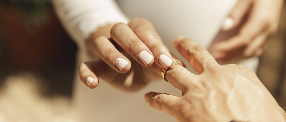 Ein Ring wird auf den Finger gesteckt – nun ist das Paar symbolisch verbunden.