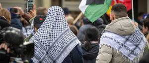 Teilnehmer der propalästinensischen Kundgebung unter dem Motto „Solidarität mit Palästina“ stehen mit Palästinenser-Tüchern und Flaggen vor der Mensa II an der Freien Universität (FU). Die Uni steht von mehreren Seiten in der Kritik, nachdem ein jüdischer Student am Wochenende von seinem propalästinensischen Kommilitonen geschlagen und getreten wurde. 
